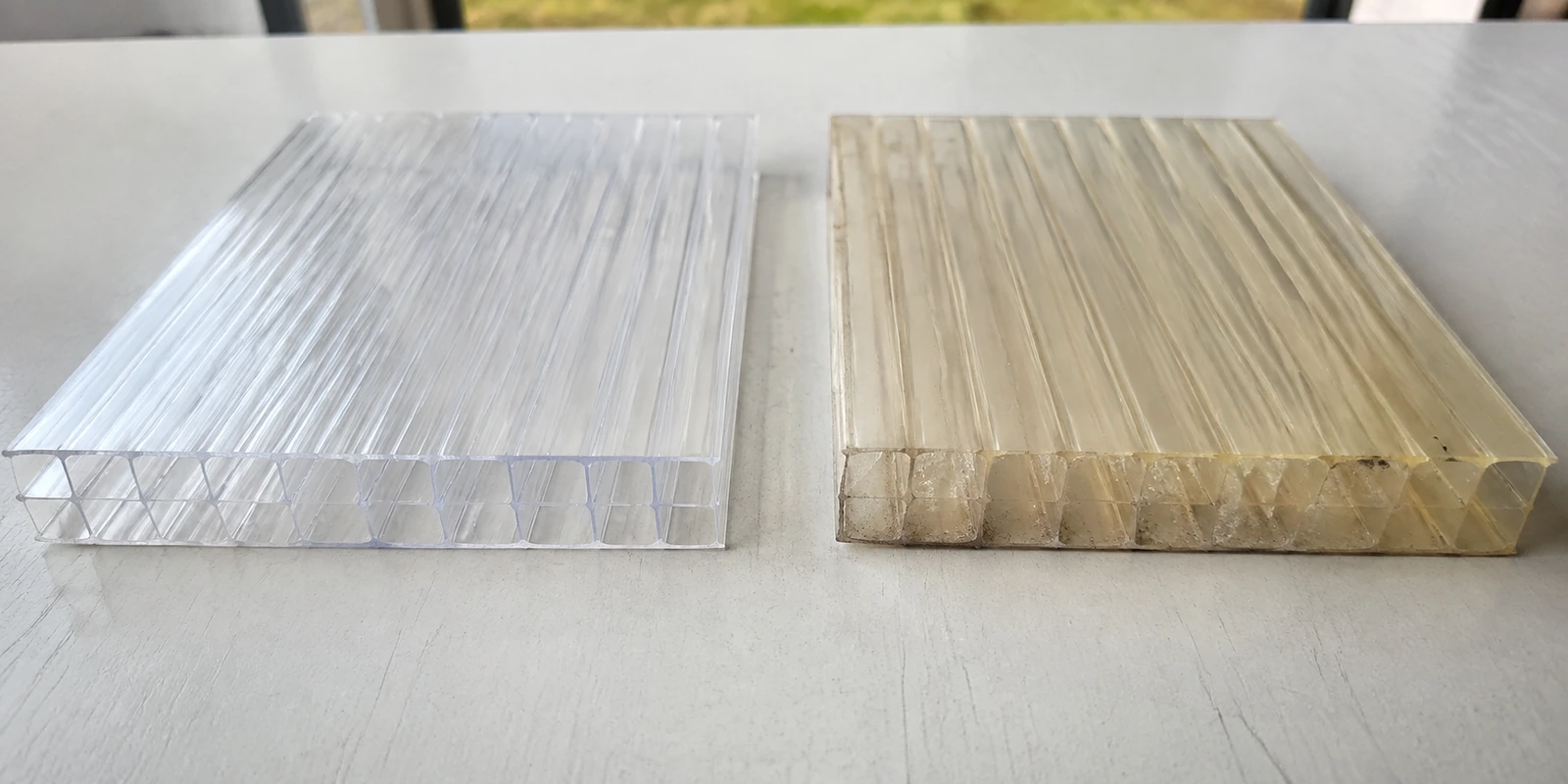 Clear and weathered multiwall polycarbonate roofing samples compared side by side